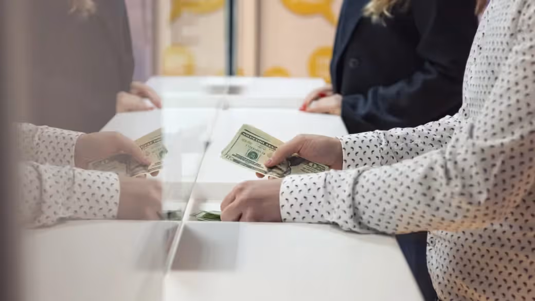 Person handing cash at a store